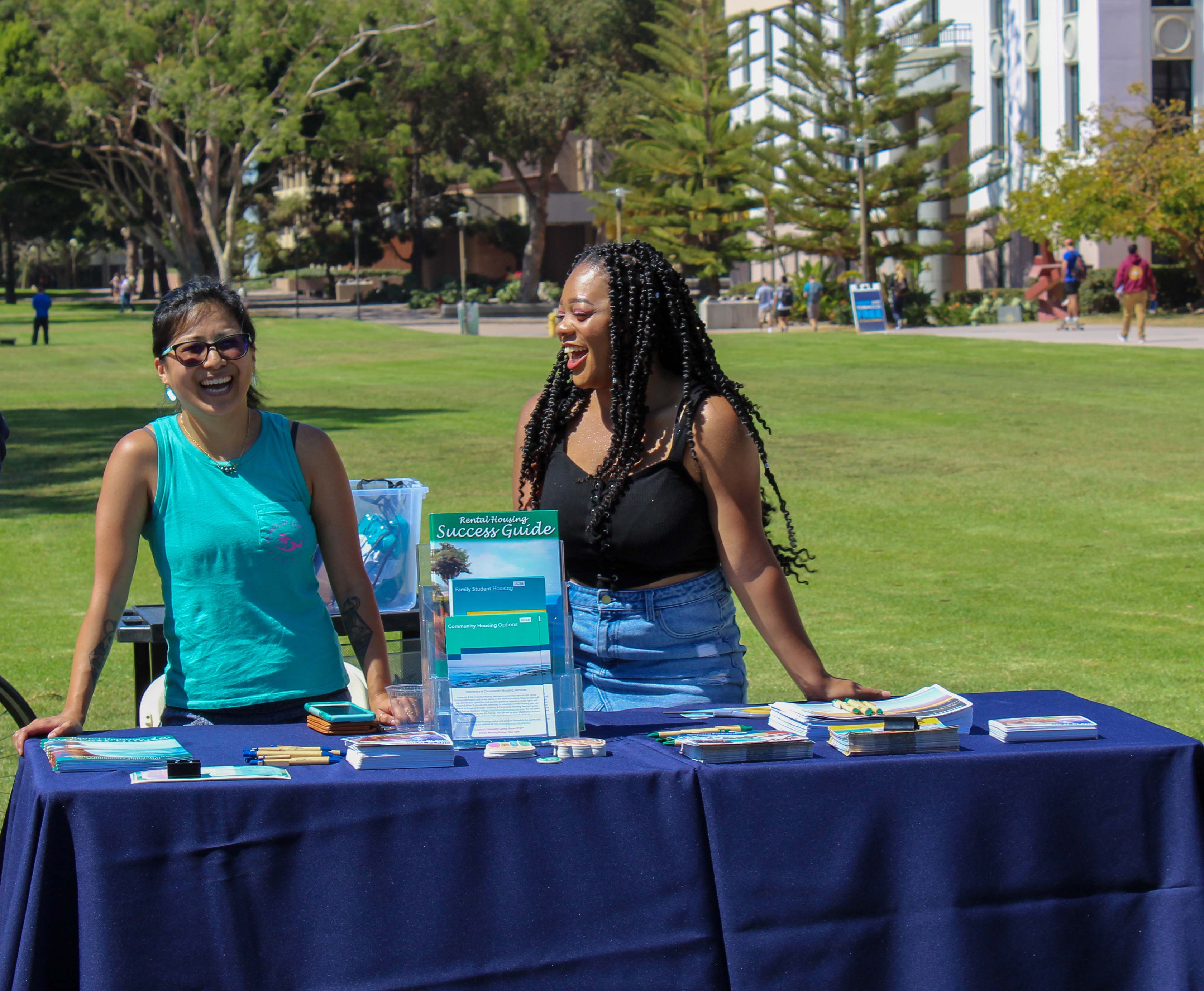 Female students standing behind Success Stories booth