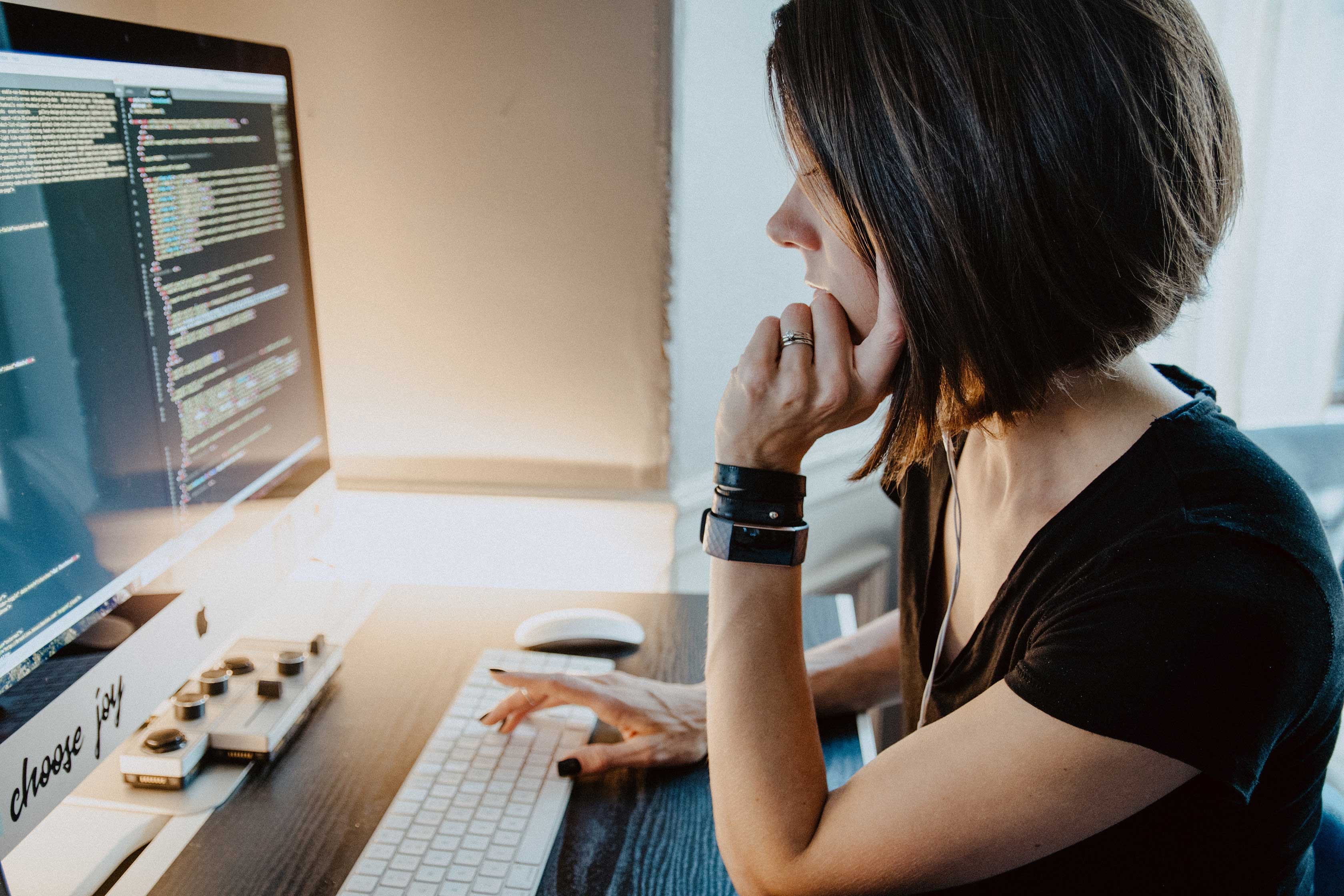 Woman in front of coding computer screen