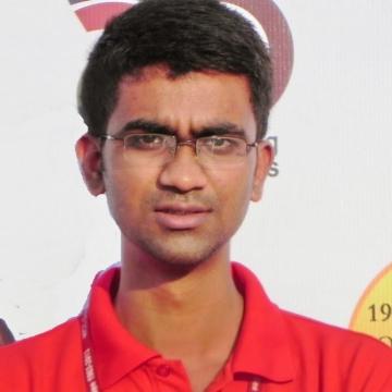 headshot of Ishtiyaque from the shoulders up, wearing a red polo and reading glasses, smiling