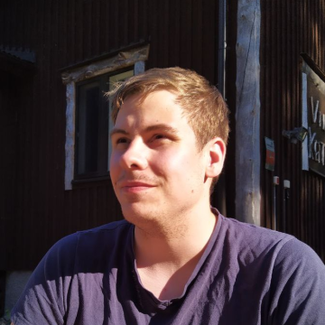 headshot of Tuukka, wearing a black t-shirt, smiling