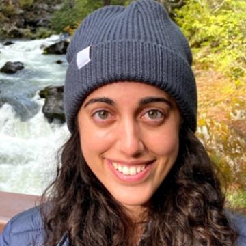 headshot of Sharon, smiling with blue beanie 