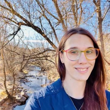 photo of Charlie, wearing a blue sweater and gold rimmed glasses